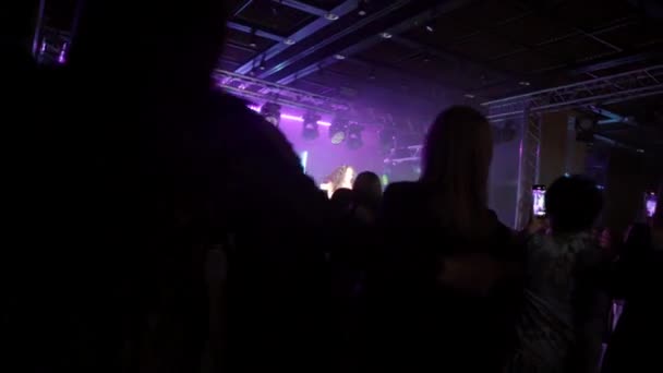 Gente bailando levanta las manos en el aire disfrutando de un concierto — Vídeos de Stock