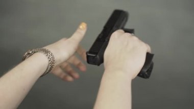 Kadın eli silah doldurur, yakın plan.