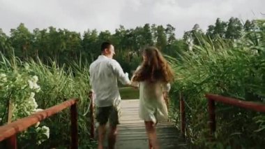 Ormanda köprüde koşan terli bir çift.