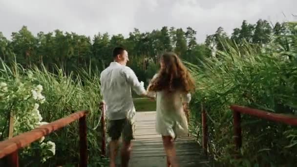 一对汗流浃背的夫妇在森林里的桥上奔跑 — 图库视频影像