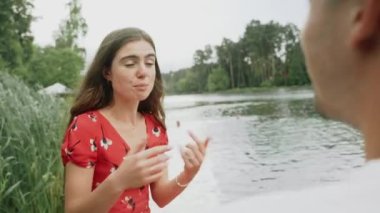  Nehirde buluşacağız. Genç bir kadın nehrin kenarında adamla konuşuyor.