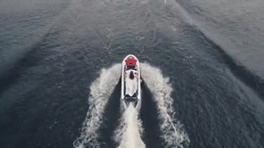 Denizde beyaz bir yatı takip eden insansız hava aracı. Jet ski