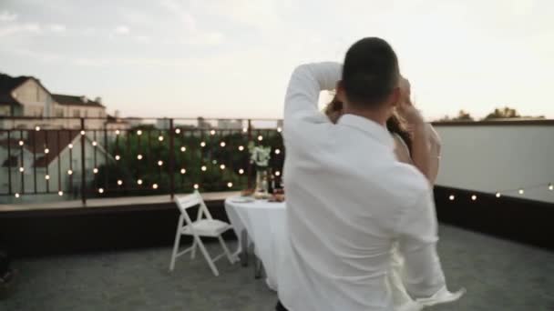 Cuplul tanar ia cina pe acoperis. Noii casatoriti se bucura de seara. — Videoclip de stoc