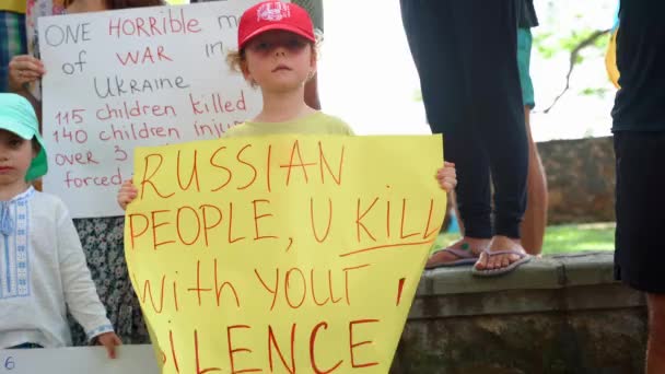 Niño pequeño con afiche pueblo ruso, matas con tu silencio. Manifestación pacífica ucraniana contra la guerra. Sri Lanka, Galle, 24 de marzo de 2022 — Vídeos de Stock