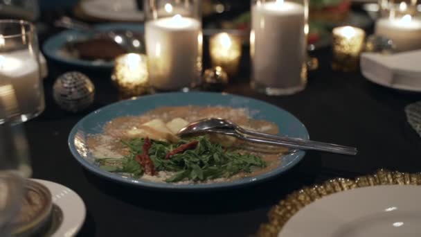 Close-up de uma luz de velas e prato com um delicioso jantar. — Vídeo de Stock