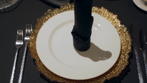 Κοντινό πλάνο ενός όμορφου τραπεζιού με ένα χρυσό πιάτο και μαύρο τραπεζομάντηλο — Αρχείο Βίντεο