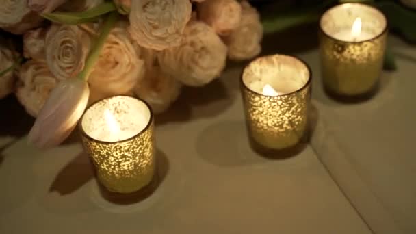 Close-up of burning candles and flower bunch. Romantic date — Stock Video