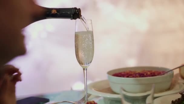 Garçom está derramando champanhe de uma garrafa em um restaurante, close up vídeo — Vídeo de Stock