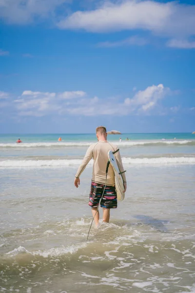 Homme avec planche de surf dans l'océan, vue arrière — Photo