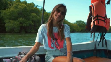Young woman resting and speaking on the boat