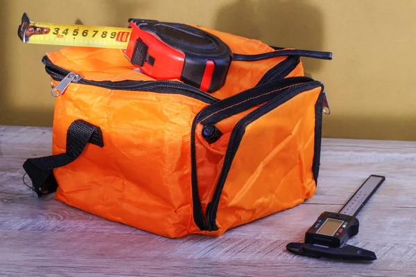 turuncu çanta kalibreleri ve miğferi masanın üzerinde.