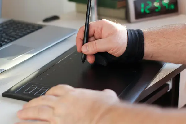 artists hands painting on a graphics tablet