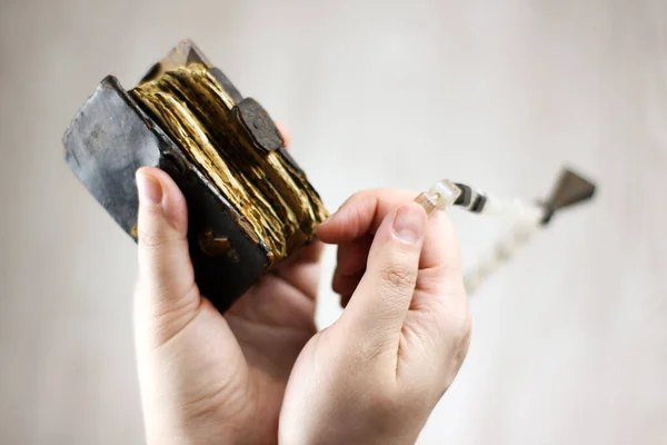 Eski dua kitabı ve tespih elinde.