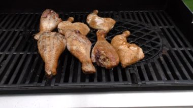 Gaz ızgarasında tel askıda tavuk budu. Tavuk budu yazın dışarıda kızartılır.