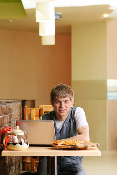 Estudiante masculino en pizzería con portátil —  Fotos de Stock