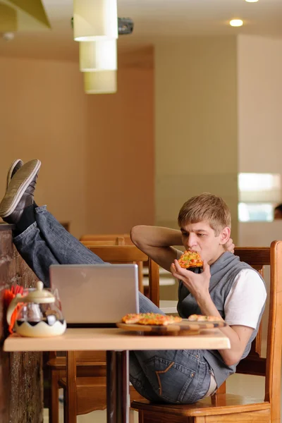 Studentowi w pizzerii z laptopa — Zdjęcie stockowe