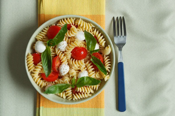Ensalada de pasta con tomates cherry y hojas de albahaca — Foto de Stock