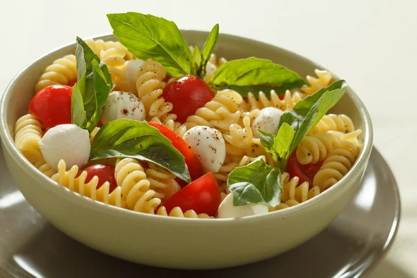 Nudelsalat mit Kirschtomaten und Basilikumblättern — Stockfoto