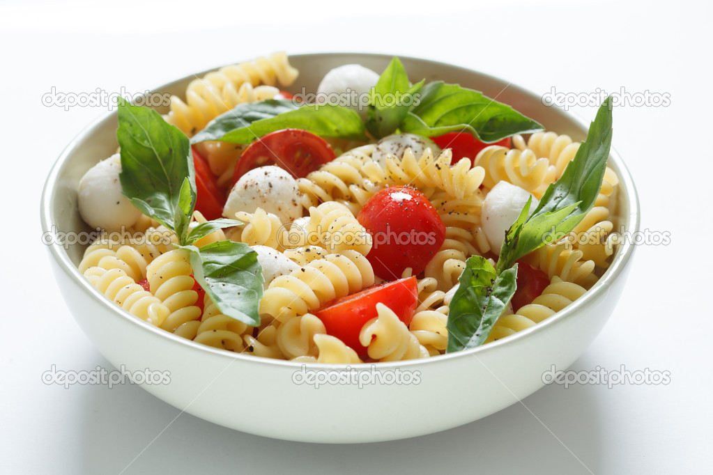 Pasta salad with cherry tomatoes and basil leaves