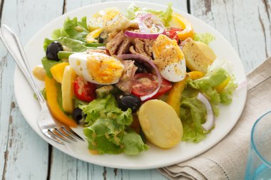 Nicoise salad over wood background clipart