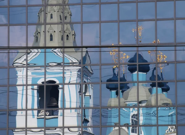 Reflexão de uma catedral ortodoxa em um arranha-céu moderno — Fotografia de Stock