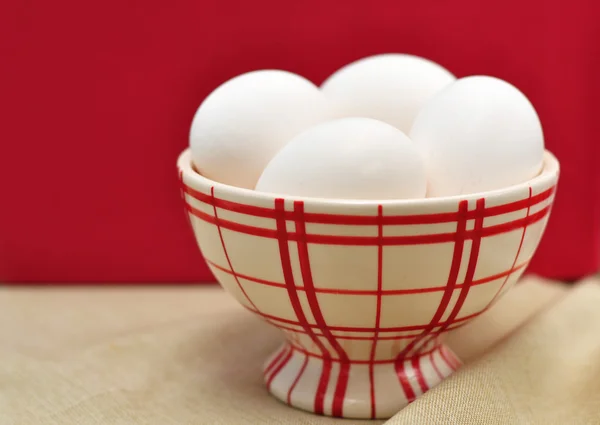 Huevos en una taza roja comprobada —  Fotos de Stock