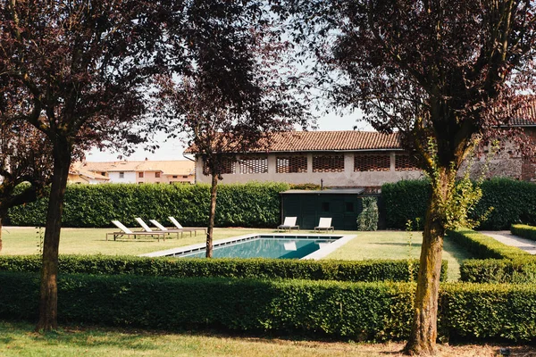 Tropical villa view with garden, swimming pool and open living room at sunset