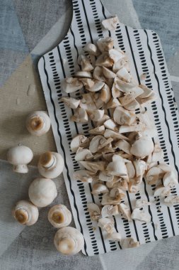 Mutfak masasının üstünde çiğ mantar şampiyonları, yemek arkaplanı.