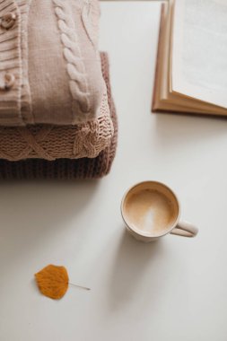 Rahat ev sonbaharı mum, kitap, örgü süveter ve ekoseyle dolu sakin bir hayat.