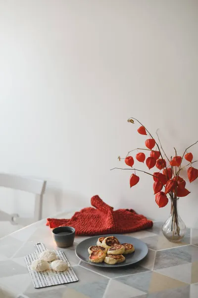 Colazione con pancake fatti in casa, una tazza di tè e fiori in un vaso sul tavolo — Foto Stock