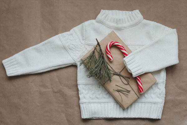 Рождественская композиция с вязаным свитером и подарком. Рождество, зима, новый год. Плоский, вид сверху.
