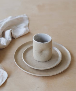Ahşap masa manzaralı seramik bardak ve tabaklar. Minimalist el yapımı seramik sofra takımı ve çömlek