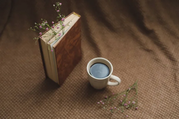 Un libro y una taza de café sobre fondo oscuro —  Fotos de Stock