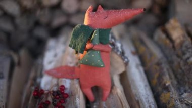 Noel, yeni yıl, kış konsepti. Noel oyuncağı tilki kar altında tahta kütükler üzerinde