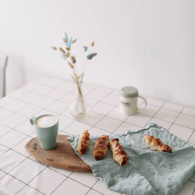 Mutfak masasında yeni pişmiş ev yapımı hamur işi. Pofuduk çöreklerle kahvaltı 