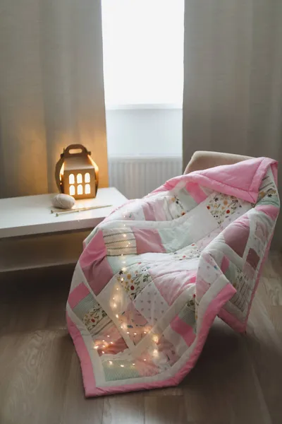 Acogedor fondo acogedor con hilo de lana y agujas de punto en un sillón con una manta. —  Fotos de Stock