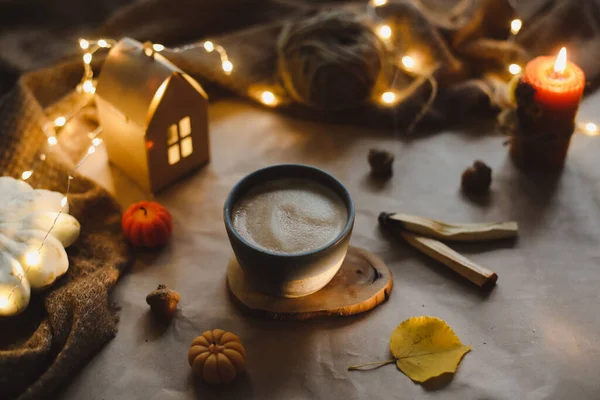 Natura morta invernale accogliente con una tazza, candele, plaid. Arredo casa Hygge. — Foto Stock