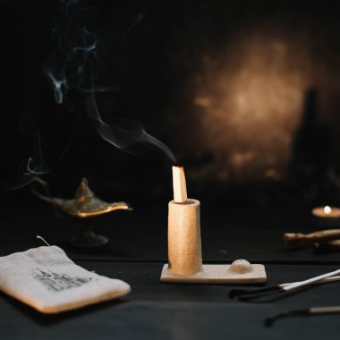 Palo Santo güzel bir şamdanda dumanla yanıyor. Evde sıcak bir akşam..