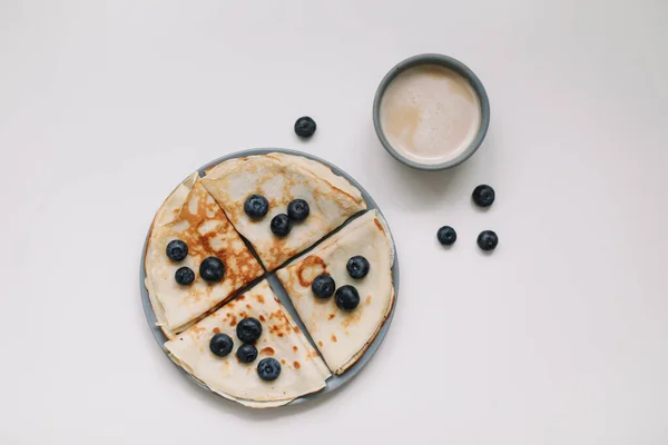 Sarapan lezat dengan pancake dengan blueberry di atas meja putih dan secangkir kopi — Stok Foto