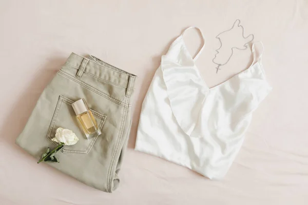 Women silk lingerie and jeans and accessories on beige background top view, flatlay — Stock Photo, Image