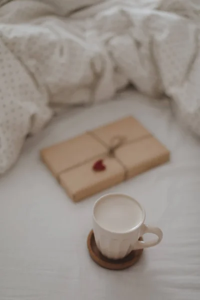 Yatakta bir fincan taze kahve, sabah havası. Pamuklu çarşaf çarşafları. Organik ve doğal keten. Yatak odasının içi rahattır. Güzel ışık. — Stok fotoğraf