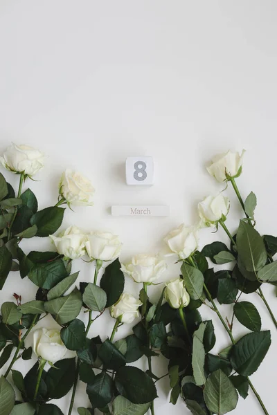 8 de marzo, Día de la Mujer fondo con rosas blancas y lugar para el texto sobre fondo blanco vista superior — Foto de Stock