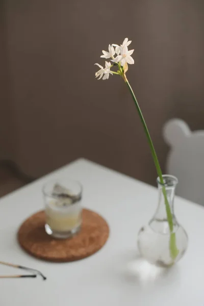Wiosna martwa natura z żonkilem wiosenny kwiat w wazonie i świeca na stole. wibracje — Zdjęcie stockowe