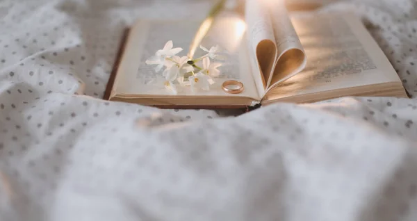 Anillo de propuesta y un libro con hojas plegadas en forma de corazón. Boda, Amor, San Valentín Concepto — Foto de Stock