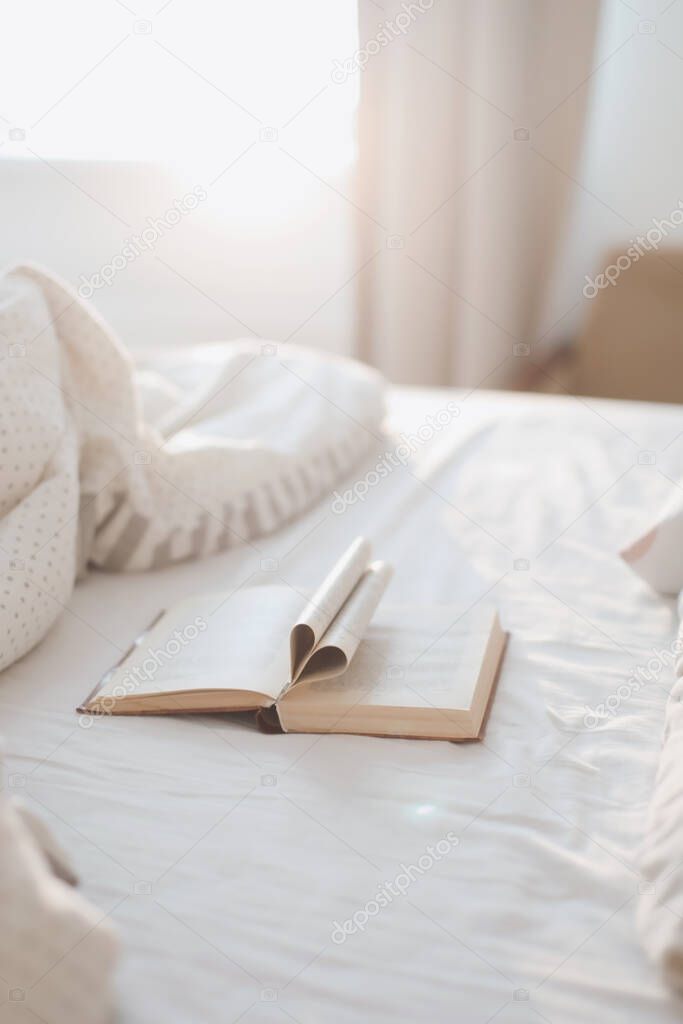Cozy morning bed with a book with pages folded into a heart shape