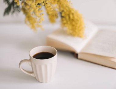 Beyaz zemin üzerinde sarı mimoza çiçekleri olan bahar kompozisyonu