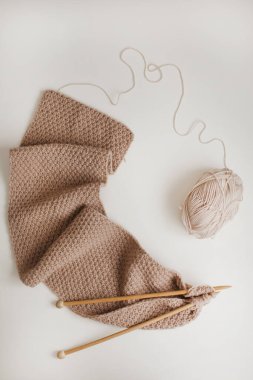 İplikle örgü iğneleri, bej iplik. Kadın konsepti hobisi. Örgü aksesuarları.