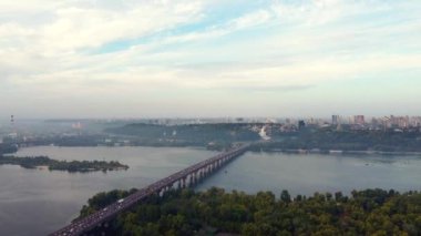 Ukrayna, Kyiv 'in merkezi. Köprüler bayrak işaretleri, konut binaları, nehir, metro insansız hava aracı manzarası.