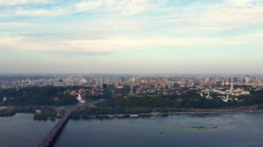 Ukrayna, Kyiv 'in merkezi. Köprüler bayrak işaretleri, konut binaları, nehir, metro insansız hava aracı manzarası.