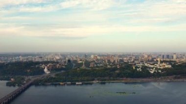 Ukrayna, Kyiv 'in merkezi. Köprüler bayrak işaretleri, konut binaları, nehir, metro insansız hava aracı manzarası.
